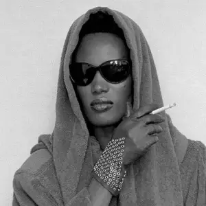 Grace Jones en 1984 portant des lunettes noires rétro-futuristes, symbolisant son style audacieux et libéré.