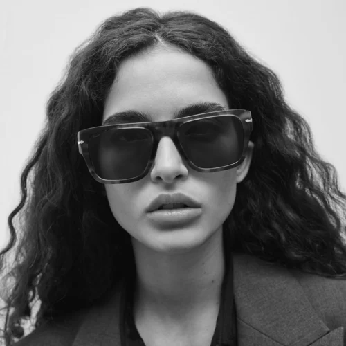 Modelo con gafas de sol Persol, campaña 2024, en blanco y negro, estilo minimalista