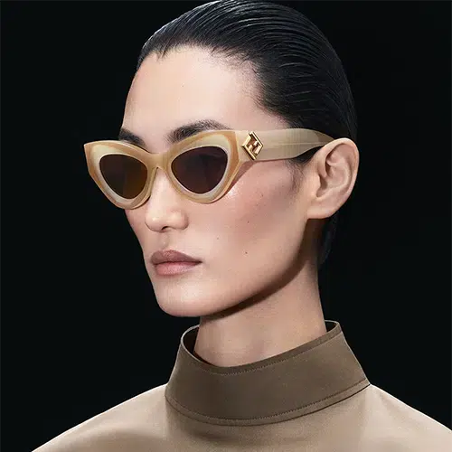 Modèle féminin portant des lunettes de soleil FENDI FF Diamonds dorées, avec une monture œil-de-chat épaisse et logo incrusté, mettant en valeur un style sophistiqué et moderne.