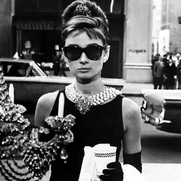 Audrey Hepburn wearing Oliver Goldsmith Manhattan sunglasses in Breakfast at Tiffany’s, a true icon of vintage style.