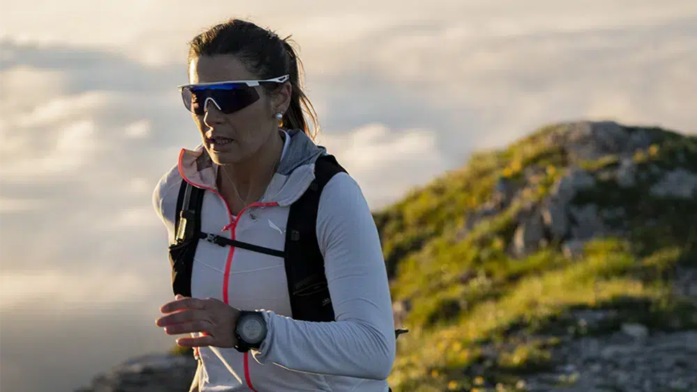 Gafas de deporte Rudy Project. Una mujer practicando trail running en la montaña con las gafas Rudy Project Turbolence, que ofrecen protección y estabilidad.