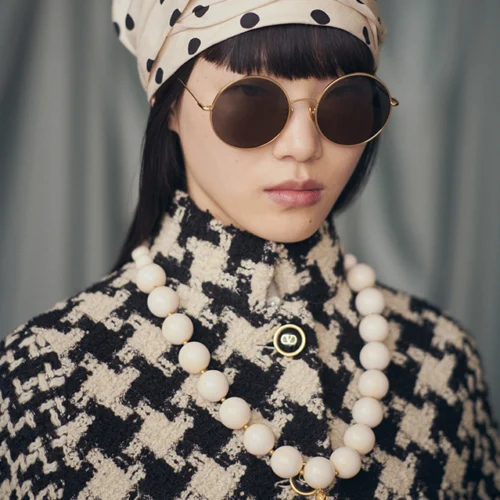 Valentino Eyewear glasses worn by a model during the Avant les Débuts collection, designed by Alessandro Michele, featuring a gold metal frame and tinted lenses.