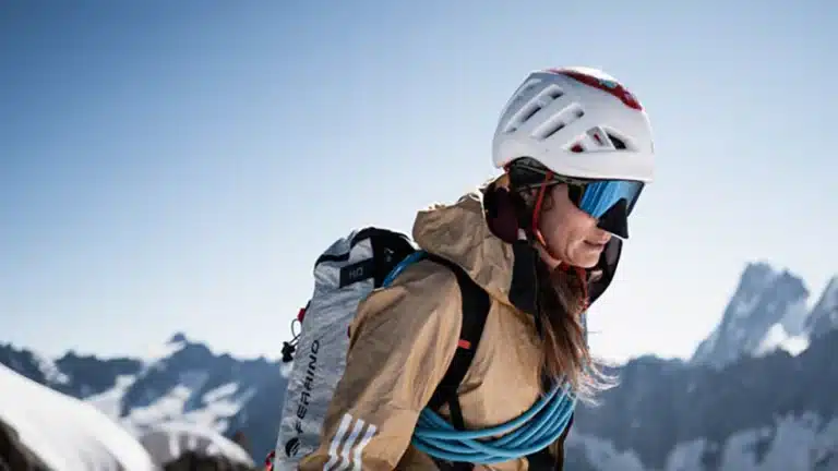 Alpiniste équipée de lunettes Julbo SUN 25 et d’un casque, progressant en haute montagne