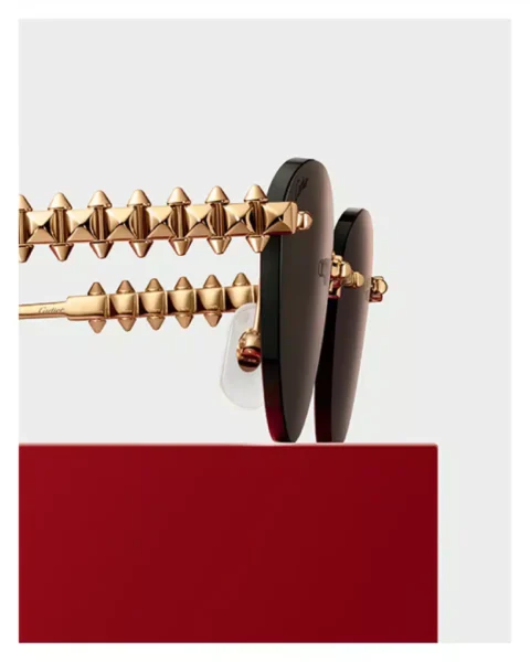 Vista ampliada de las varillas con clavos móviles en una montura Clash de Cartier 2025 en metal dorado