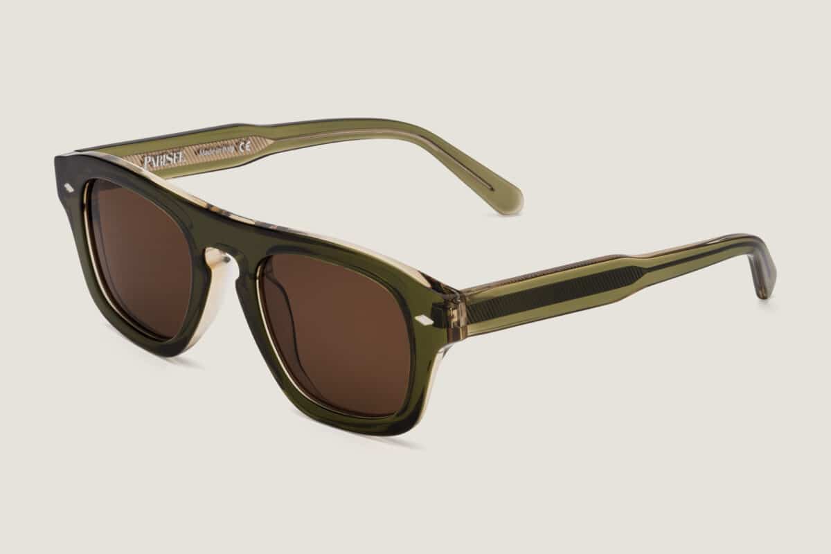 Vista en tres cuartos de las gafas de sol Freschezza en acetato verde oliva translúcido con lentes marrones, sobre fondo claro