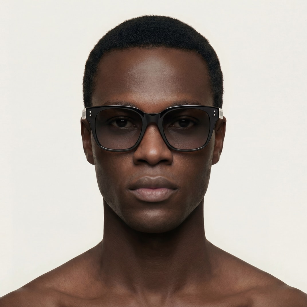 Retrato de estudio de un hombre con gafas de sol negras PARISEE, forma rectangular suavizada, lentes oscuras.