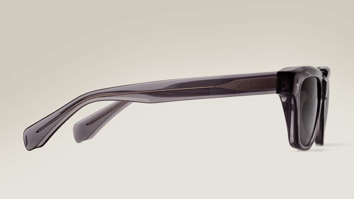 Vista de perfil de las gafas de sol Essentiel N2 sobre fondo claro: montura rectangular de acetato ahumado translúcido, varillas largas y lentes gris oscuro