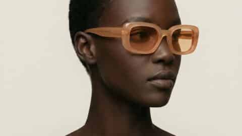 Retrato de estudio de una modelo con gafas de sol Parisee Eyewear Essentiel N3 beige translúcido, montura rectangular suavizada, lentes claras